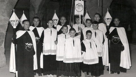 17. Josep M. Martí Carnicer ens envia aquesta foto de la Confraria de la Verge de Montserrat. Abril 1961. Darrere: Antoni Prats, Joan Naboa, escolà Eusebi Perelló (amb el penó), Antoni Ortís. Mig: Josep Serra, tres escolans: Josep Perelló, Josep M. Martí 