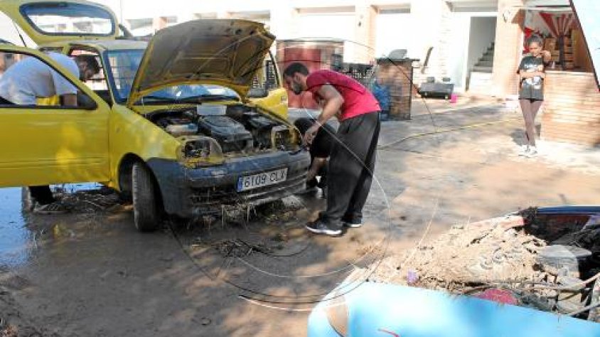 Afectats i voluntaris reparant un dels vehicles afectats per la rubinada