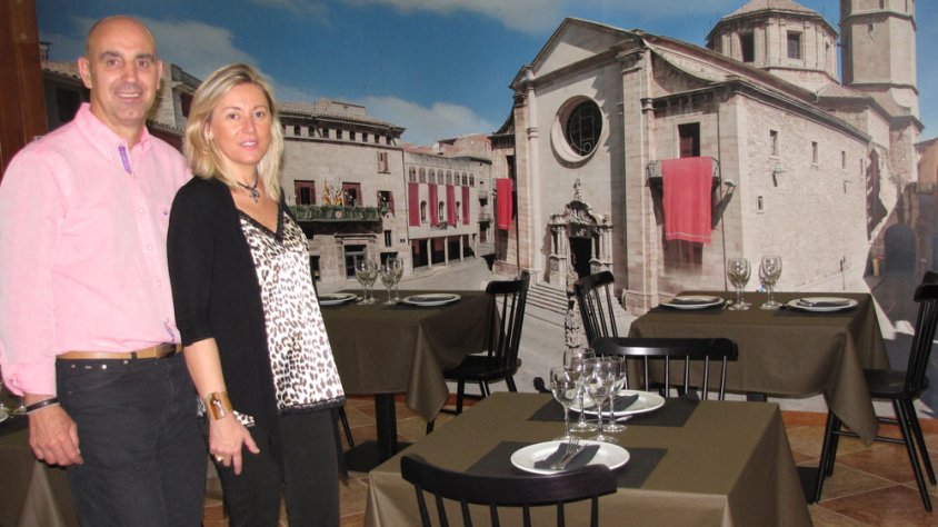 Els actuals propietaris de l’Hotel Ciutat de Tàrrega ens ensenyen una de les sales del restaurant de l’establiment que està presidida per una fotografia gegantina de la plaça Major de la ciutat