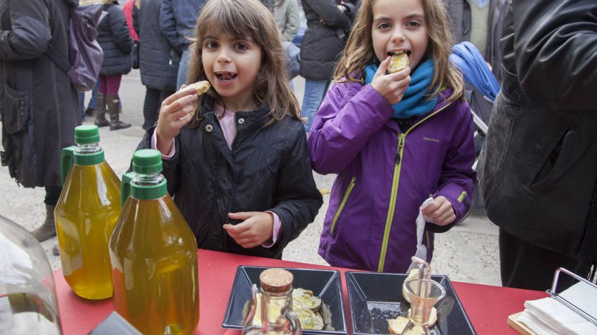Dues nenes menjant-se una llesca de pa sucat amb oli