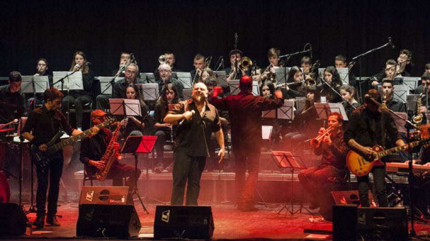 La banda amb l’Orquestra de l’EMMT al fons