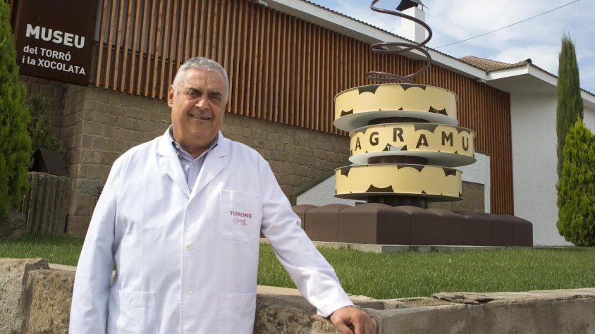 Ángel Velasco, al costat de l'escultura commemorativa a l'entrada de la fàbrica