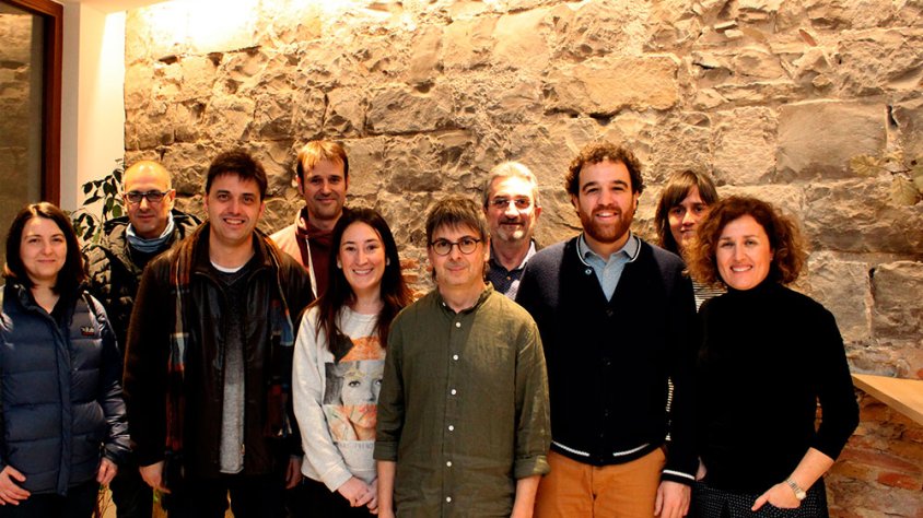 Regidors del consistori, arqueòlegs municipals i responsables de la clínica dental davant un segment de muralla preservat dins l’edifici