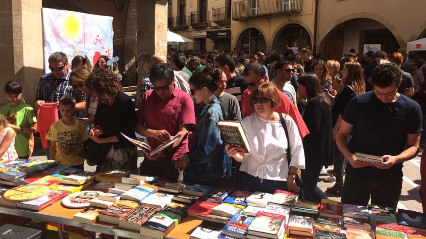Visitants del mercat mirant llibres en una de les parades