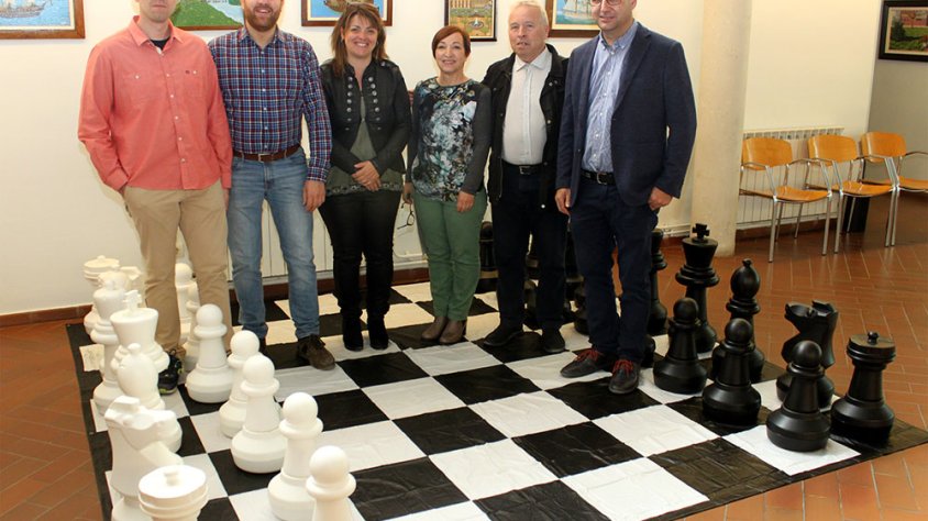 La regidora d’Acció Social, Noèlia Soto; el regidor de Cultura, Raül Palacios; la directora del Casal Cívic, Imma Cabiscol; el gran mestre d’escacs Josep Oms; i representants del Club Escacs Tàrrega amb el tauler gegant que també s’usarà en algunes sessio
