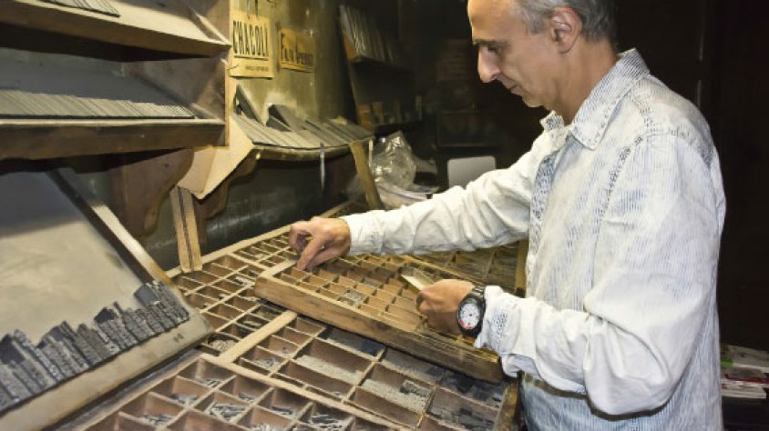 Francesc Sauret component un text per la posterior impressió