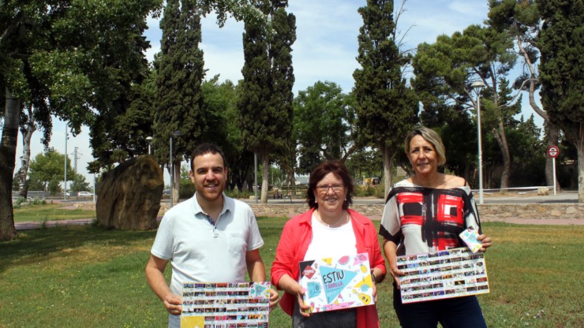 L’alcaldessa Rosa Maria Perelló; el regidor de Cultura, Raül Palacios; i la tècnica de Cultura, Teresa Garcia; amb una reproducció del fulletó d’estiu davant el Camp dels Escolapis, un dels escenaris de la programació