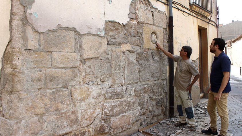 El regidor de Cultura, Raül Palacios, i l’arqueòleg municipal, Oriol Saula, davant la part baixa de la torre, on s’ha posat al descobert una espitllera