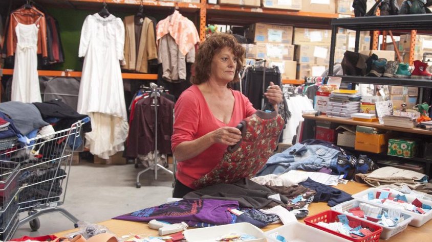 Una treballadora selecciona roba a la seu de Cartaes, en una nau del polígon Riambau