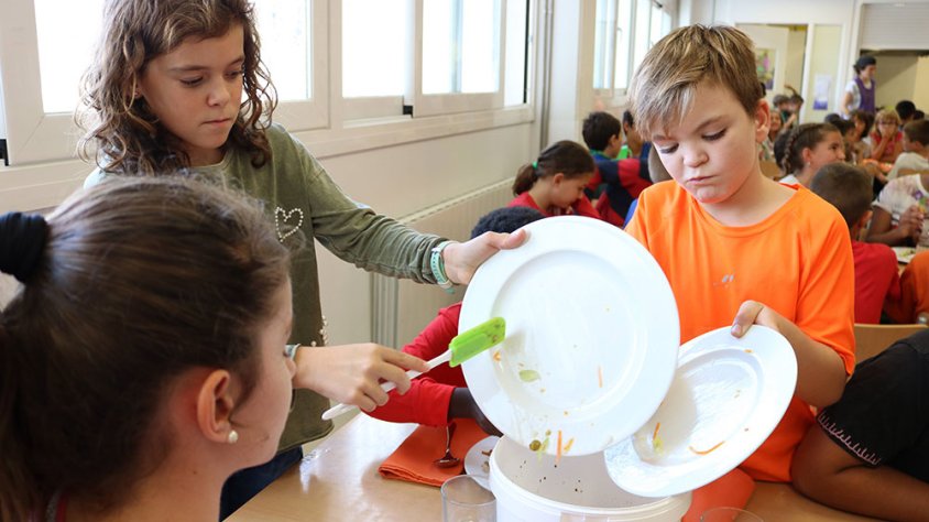 Alumnes recollint restes de menjar