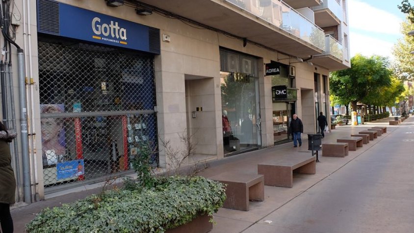 Un comerç amb la persiana abaixada al costat d'un altre que va decidir obrir