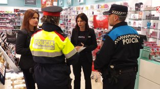 Una patrulla Albatros, formada per un mosso i un policia, informant sobre el dispositiu Grèvol a treballadores d'un comerç