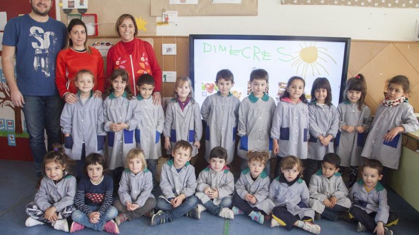 Alumnes i representants de l'escola davant de la nova pissarra