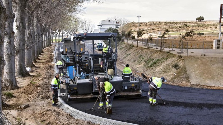 Operaris asfaltant ahir uns dels accessos situats darrere de la graella de sortida