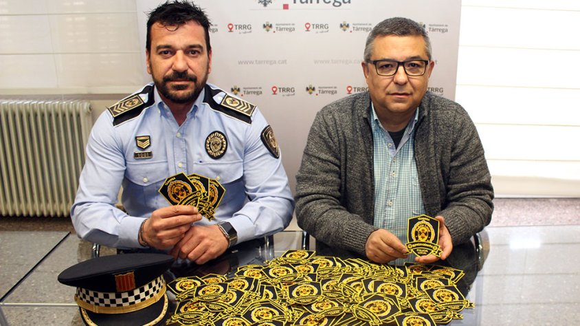 El regidor de Governació, Carles Pascual, i el sotsinspector de la Policia Local de Tàrrega, Àlex Dalghi, amb els escuts solidaris destinats a la lluita contra el càncer infantil