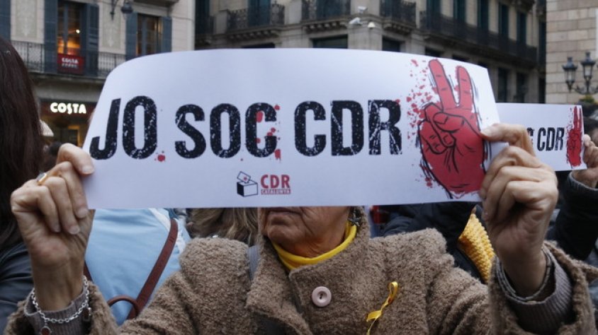 Una dona mostra una pancarta de suport als CDR