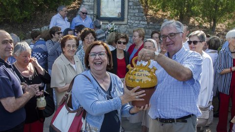 Jaume Aligué lliurant un càntir amb aigua beneïda a l'alcaldessa