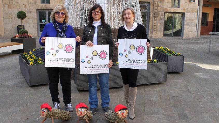 L’alcaldessa de Tàrrega, Alba Pijuan Vallverdú, amb la regidora de Promoció Econòmica, Núria Robert, i la tècnica de Promoció Econòmica, Anna Castellà, mostrant el cartell de la 21a Fira d’Artistes i Activitats Tradicionals