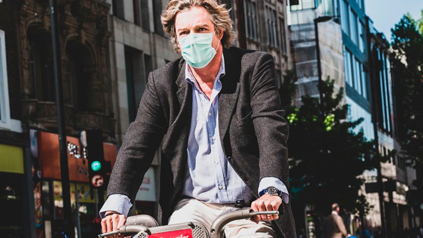 Un home que va en bicicleta duu una màscara