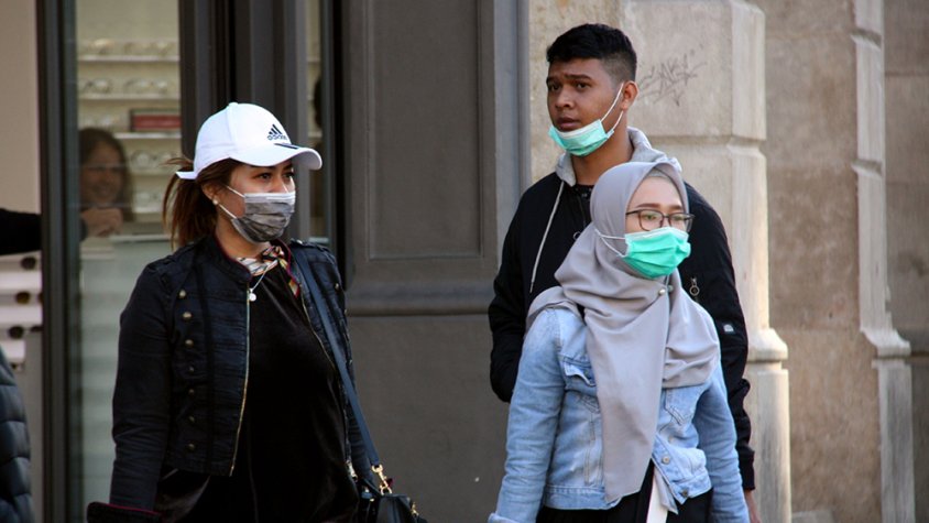 Ciutadans passejant pels carrers del centre de Barcelona amb mascaretes, l'11 de març del 2020