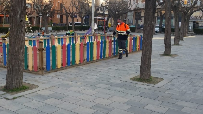 Un operari de la Brigada Municipal netejant un parc infantil