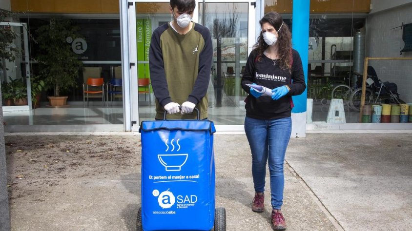 Dos voluntaris transportant el menjar a domicili