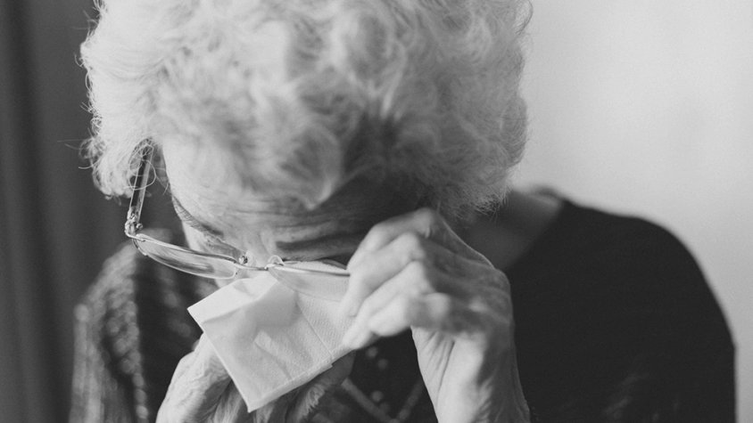 Una senyora gran eixugant-se els ulls