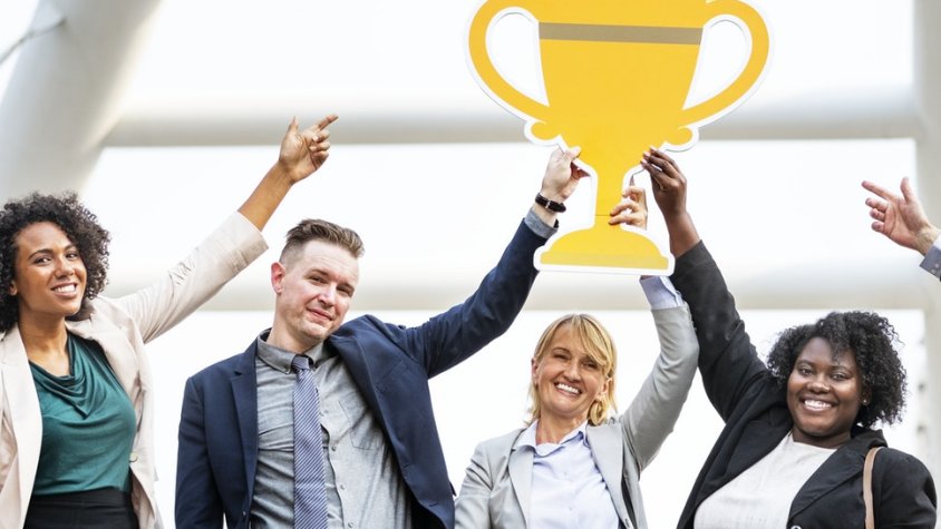 Un grup de gent aguantant una icona d'un trofeu