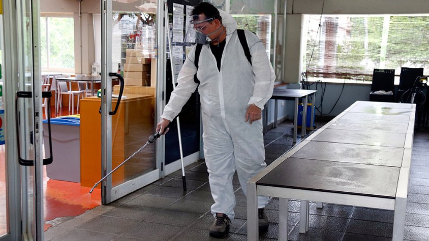 Un treballador desinfectant la terrassa del restaurant El Gat de Tàrrega