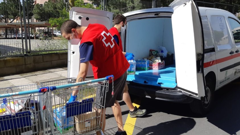 Voluntaria carregant llet d'un supermercat
