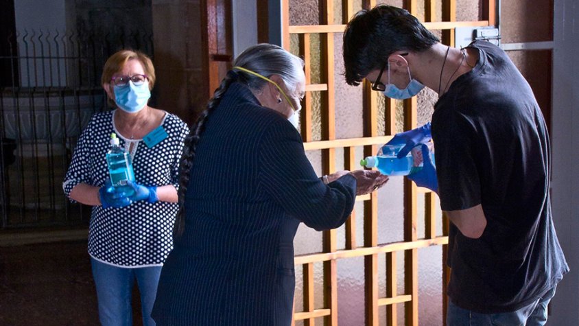 Voluntaris repartint gel hidroalcohòlic als fidels en arribar a l'església