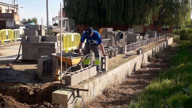 Operaris municipals treballant en la construcció del mur exterior