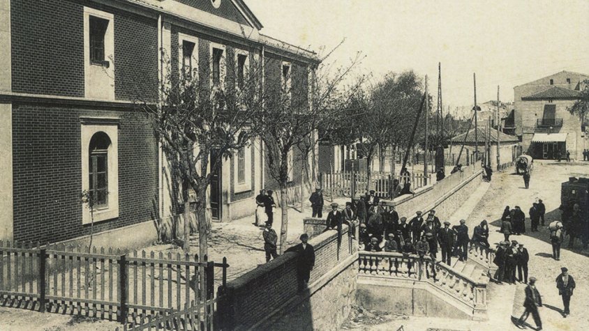 Sota l'escala d'accés a l'estació de tren, el carrer del Segle XX els anys vint