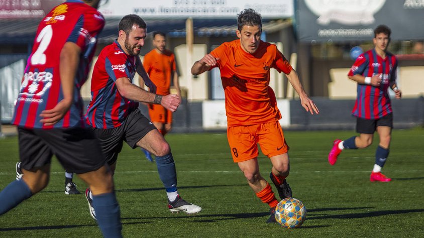 Roger Canadell, de l’At. Lleida, porta la pilota davant de la presència de diversos jugadors del Tàrrega, equip que va ser superior