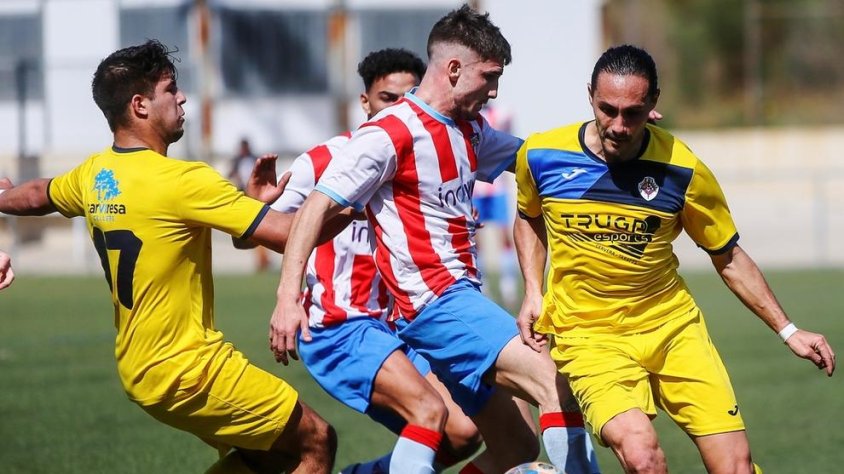 Jugadors dels dos equips pugnen per una pilota dividida