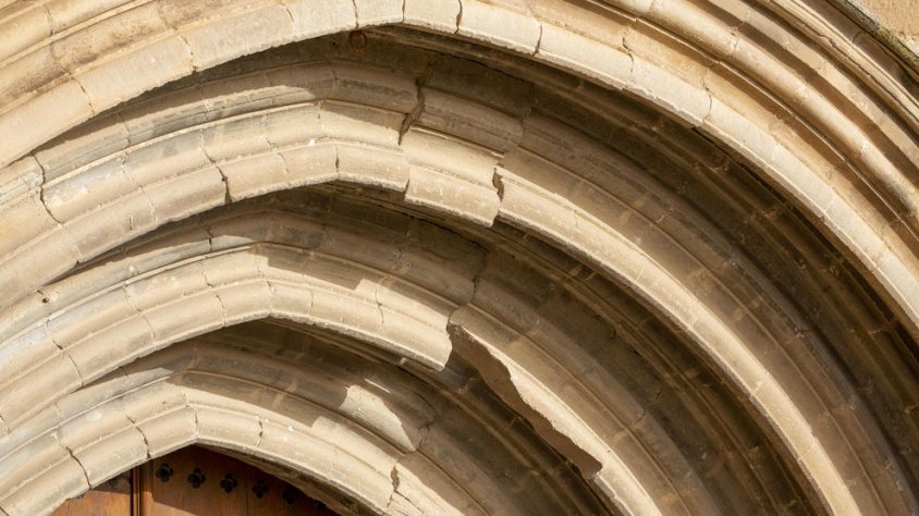 Dovelles desplaçades a l’arc de la porta de l’església