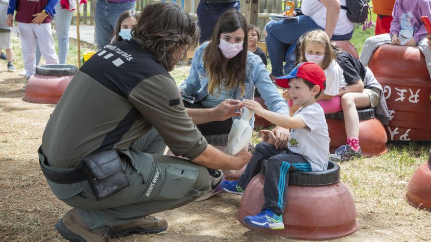 Un agent rural mostrant una au a un dels infants que van participar en l'activitat