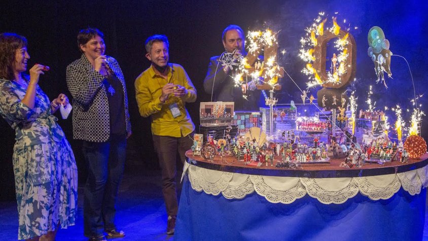 Les autoritats bufant les espelmes del pastís-maqueta d'aniversari