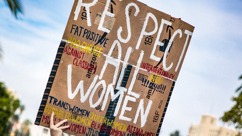 Una noia amb una pancarta defensant els drets de les dones