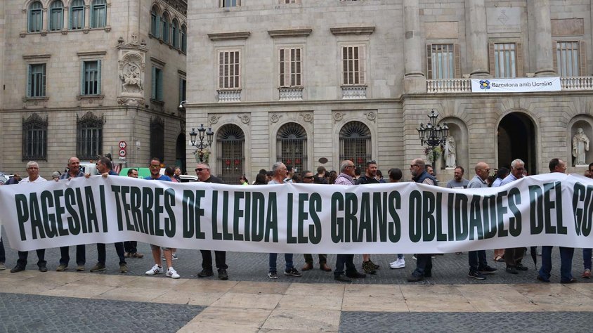 Pagesos aixecant una pancarta davant de la Generalitat
