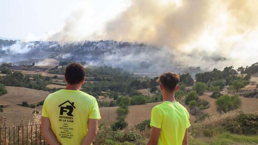 Dos homes observant com avançava l'incendi des de Belltall