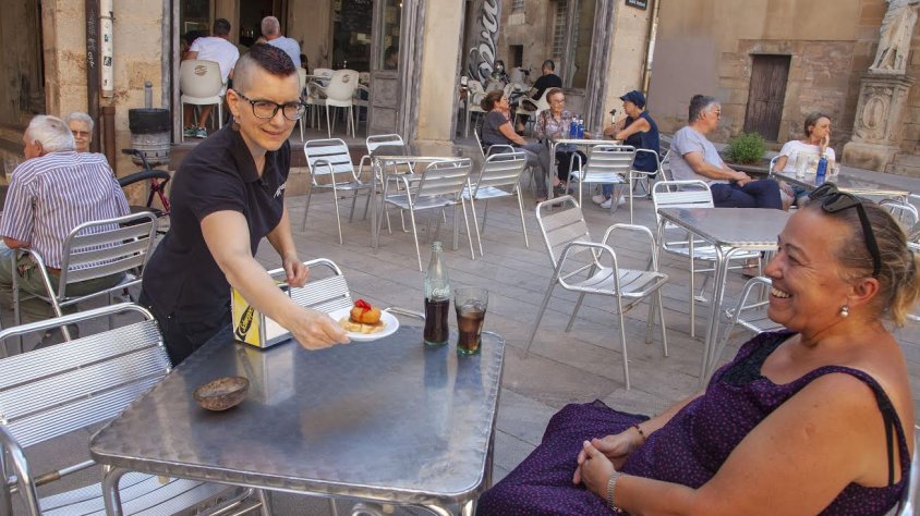 La responsable del bar Nòvum serveix la tapa a una clienta