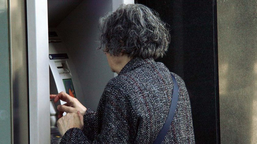 Una persona utilitzant un caixer automàtic