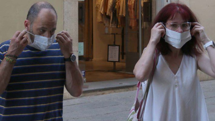 Dues persones col·locant-se la mascareta