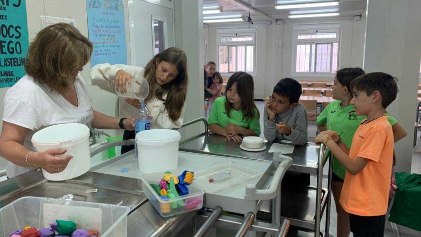 Infants recollint l'aigua sobrant del dinar