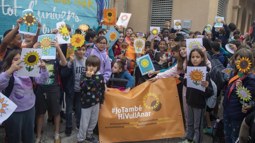 Escolars amb la pancarta i girasols