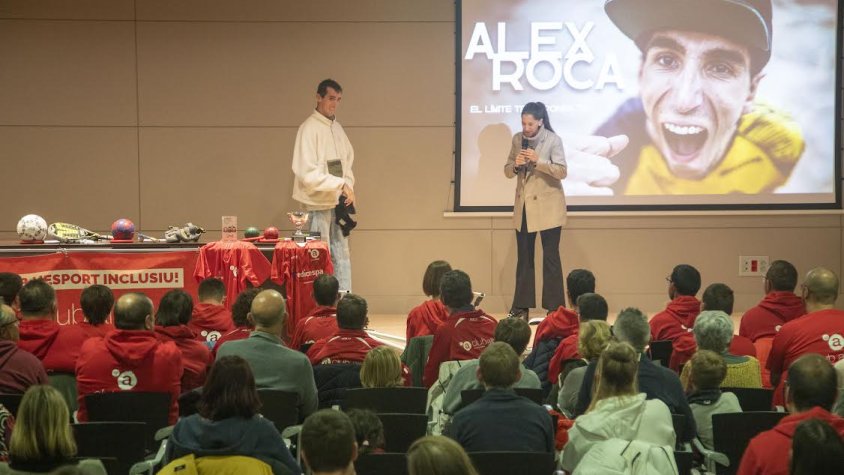 Un moment de la xerrada d'Àlex acompanyat de Mari Carme Maza, la seva parella i intèrpret