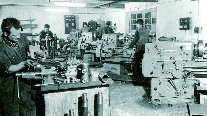 En els seus orígens transformava la fusta i construïa remolcs, cisternes i equips d'ús agrícola