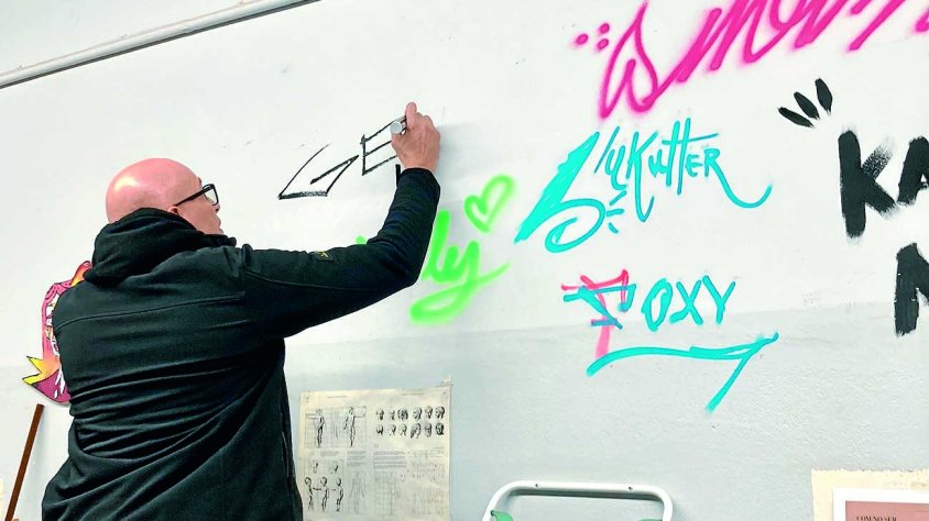 Gerada va firmar en una paret d'una aula al centre al costat d'altres artistes que l'han visitat