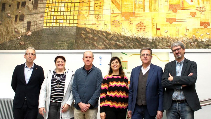 El pintor Josep Minguell amb el seu mural a l'ajuntament i representants institucionals